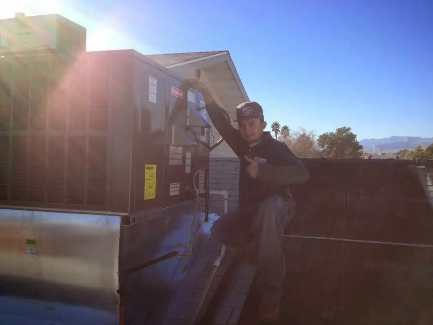 HVAC technician performing AC Tune-Up on a rooftop unit in Cobleskill